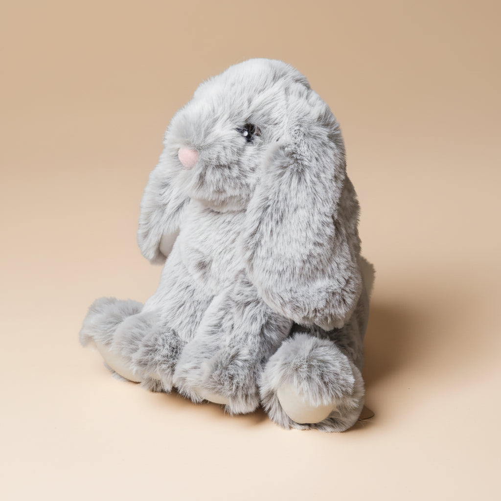 Gray plush little-lottie-bunny-grey toy on a beige background