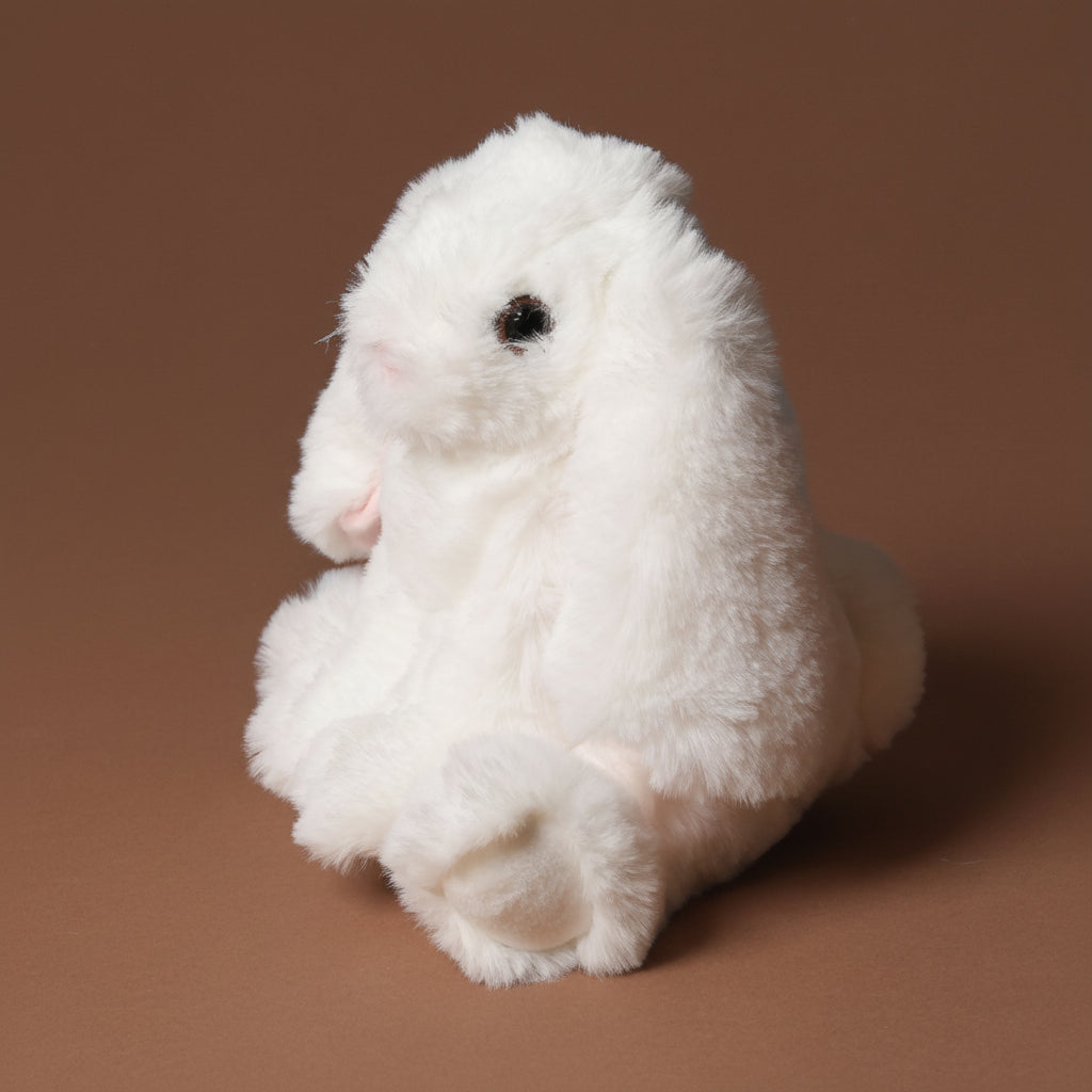 White plush little-lottie-bunny-white toy on a brown background