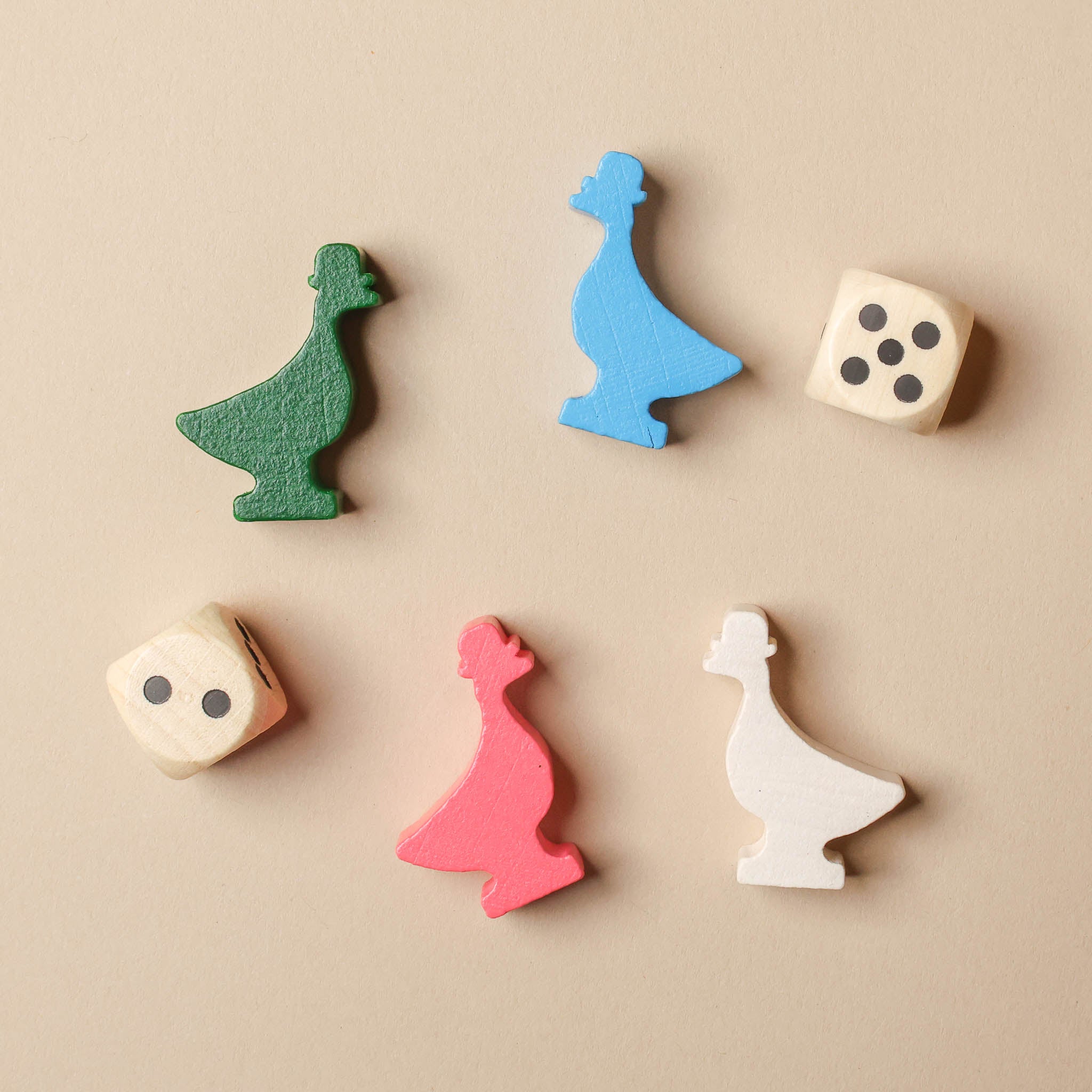 Colorful wooden game pieces and dice on a beige background