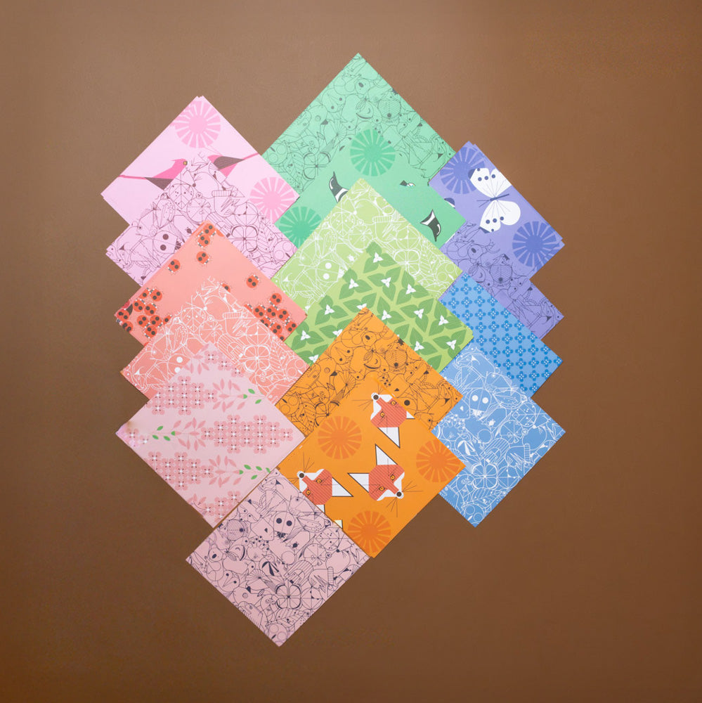 make-your-own-charley-harper-origami-animals-kit Collection of origami paper  squares arranged in a diamond pattern on a brown background