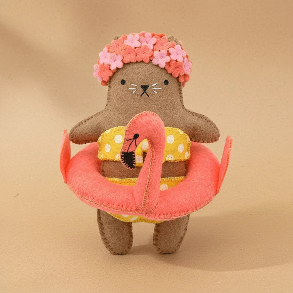 Plush toy cat wearing a swimsuit and flower crown on a white background