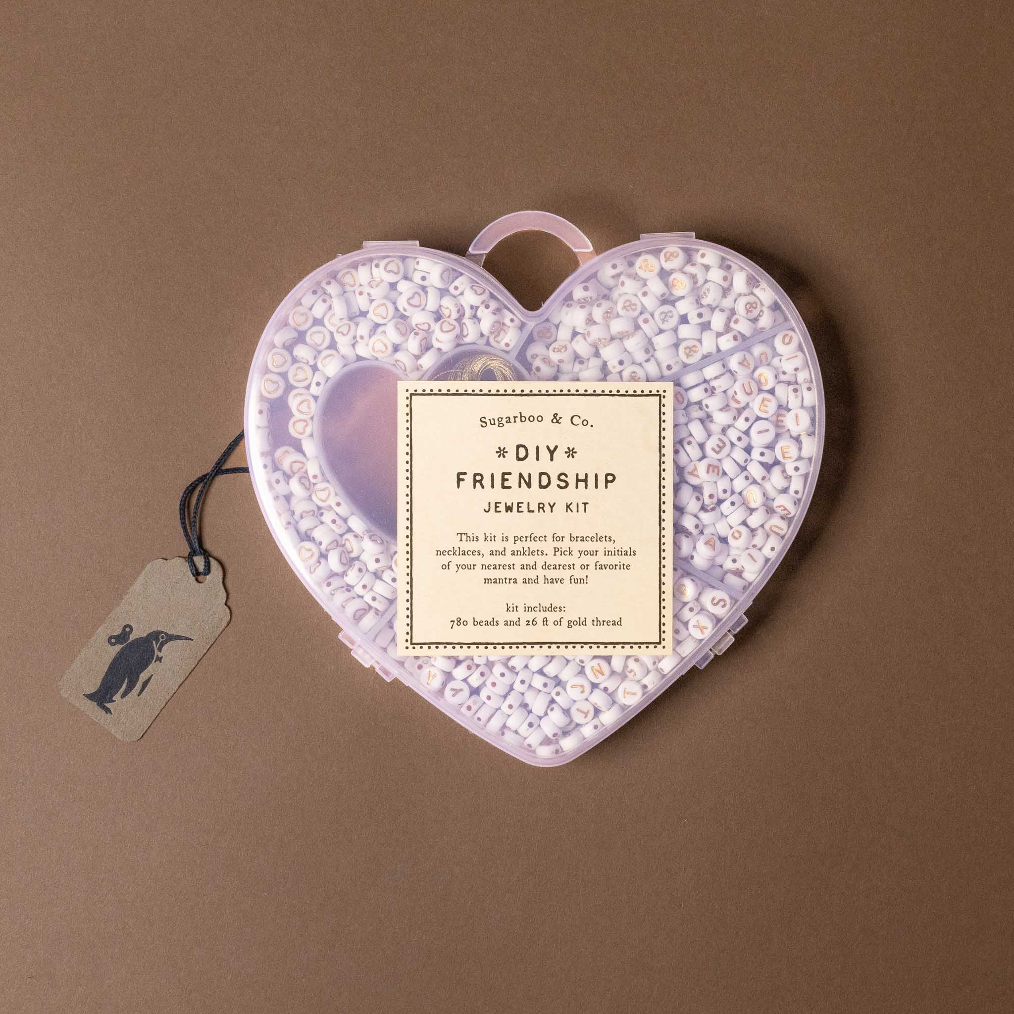Heart-shaped DIY friendship jewelry kit with a tag on a brown background