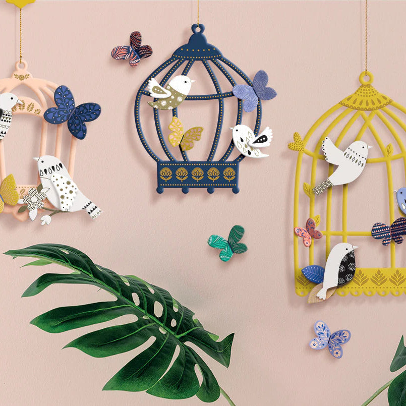 Decorative birdcages with birds and butterflies on a pink background