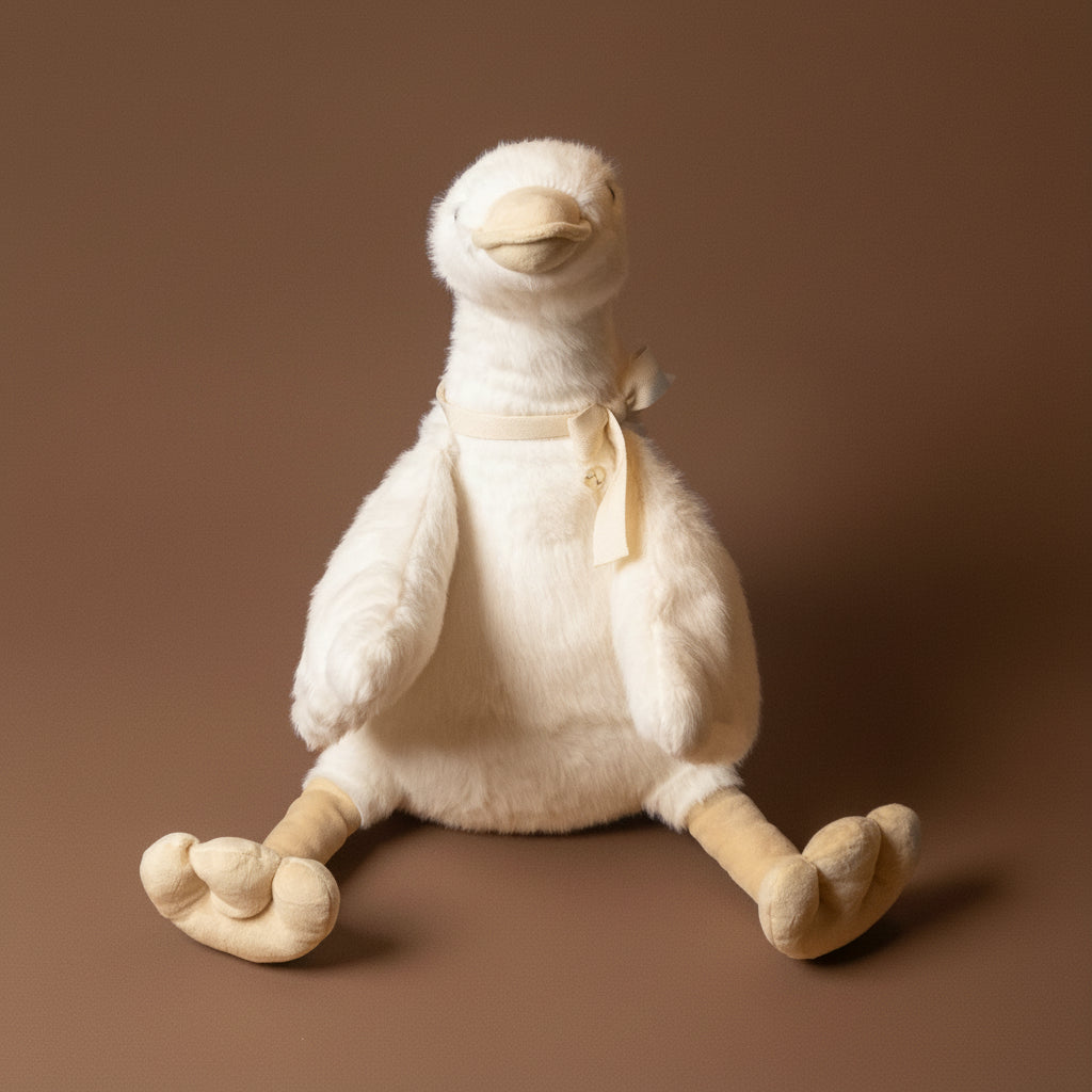 White plush duck toy with a bow on a brown background