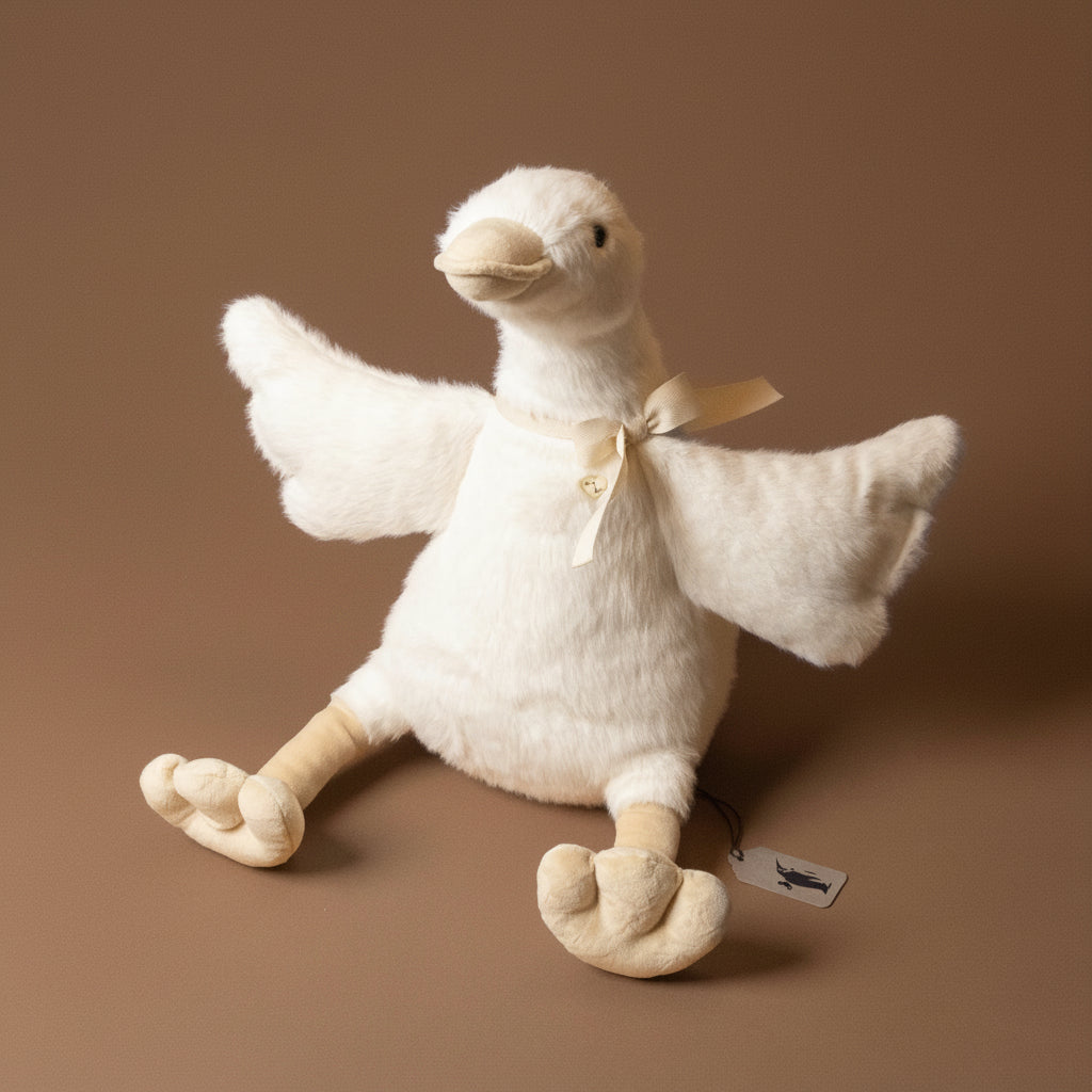 White plush duck toy with a bow on a brown background