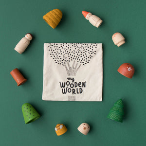 wooden-block-shapes-people-animals-plants-surrounding-muslin-carrying-bag-stamped-with-my-wooden-world-tree