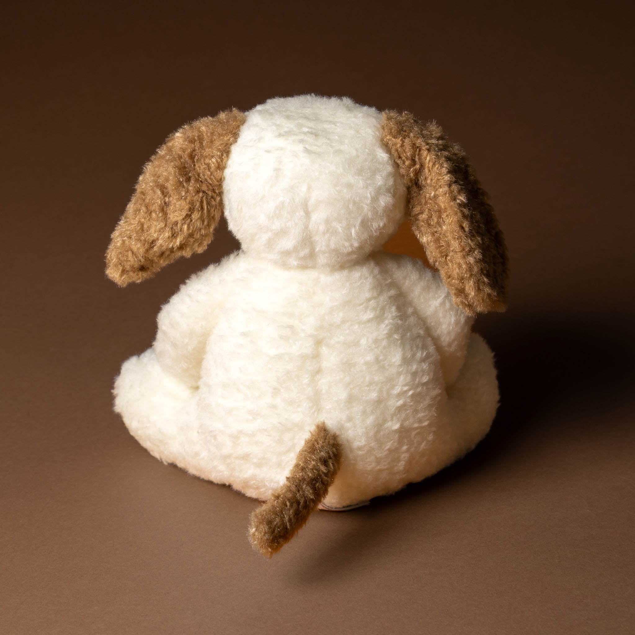 nafi-puppy-grande White plush dog toy with brown ears and tail on a brown background