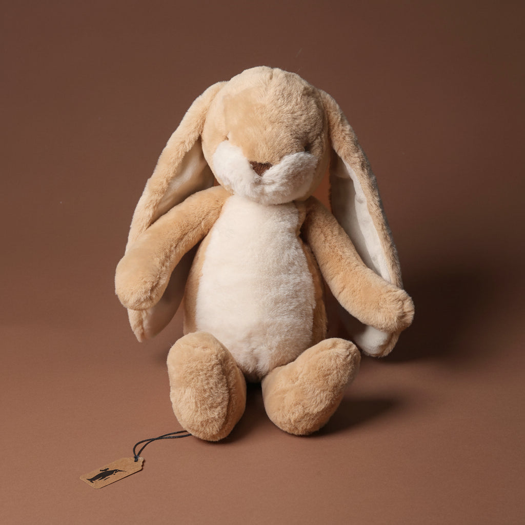 Plush nibbles-bunny-almond-medium toy on a brown background