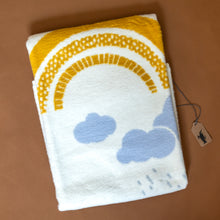 Load image into Gallery viewer, organic-cotton-baby-blanket-yellow-rainbow-and-sun-with-blue-grey-clouds-and-raindrops-on-cream-backdrop