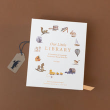 Load image into Gallery viewer, our-little-library-box-set-case-with-a-ball-oranges-bird-boat-hot-air-balloon-bunny-and-others-on-soft-white-with-gold-foil-writing