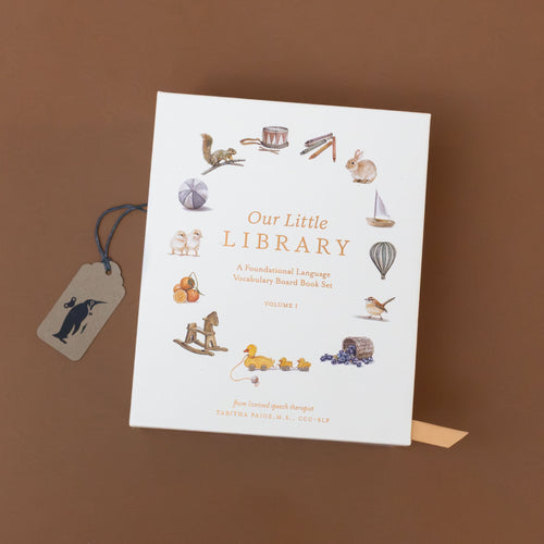 our-little-library-box-set-case-with-a-ball-oranges-bird-boat-hot-air-balloon-bunny-and-others-on-soft-white-with-gold-foil-writing
