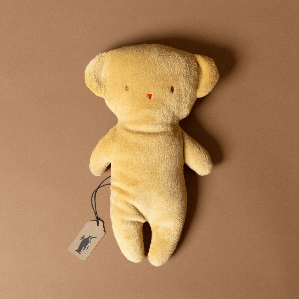 pancake-teddy bear stuffed-animal with a tag on a brown background