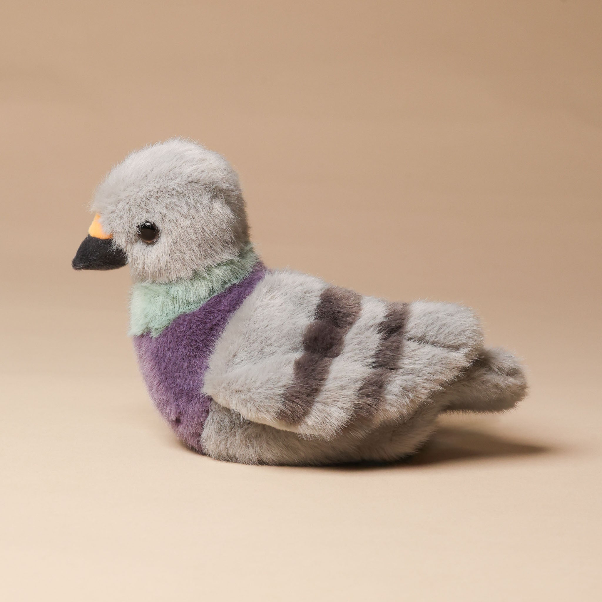 Plush toy pigeon with a striped pattern on a beige background