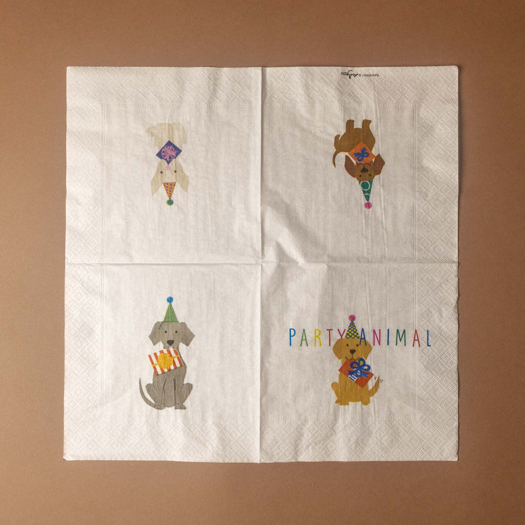 Four white paper napkins arranged in a 2x2 grid on a brown background. Each napkin features a different cartoon animal wearing a party hat and holding a party popper or cake, with one napkin reading 'PARTY ANIMAL' in multicolored letters.