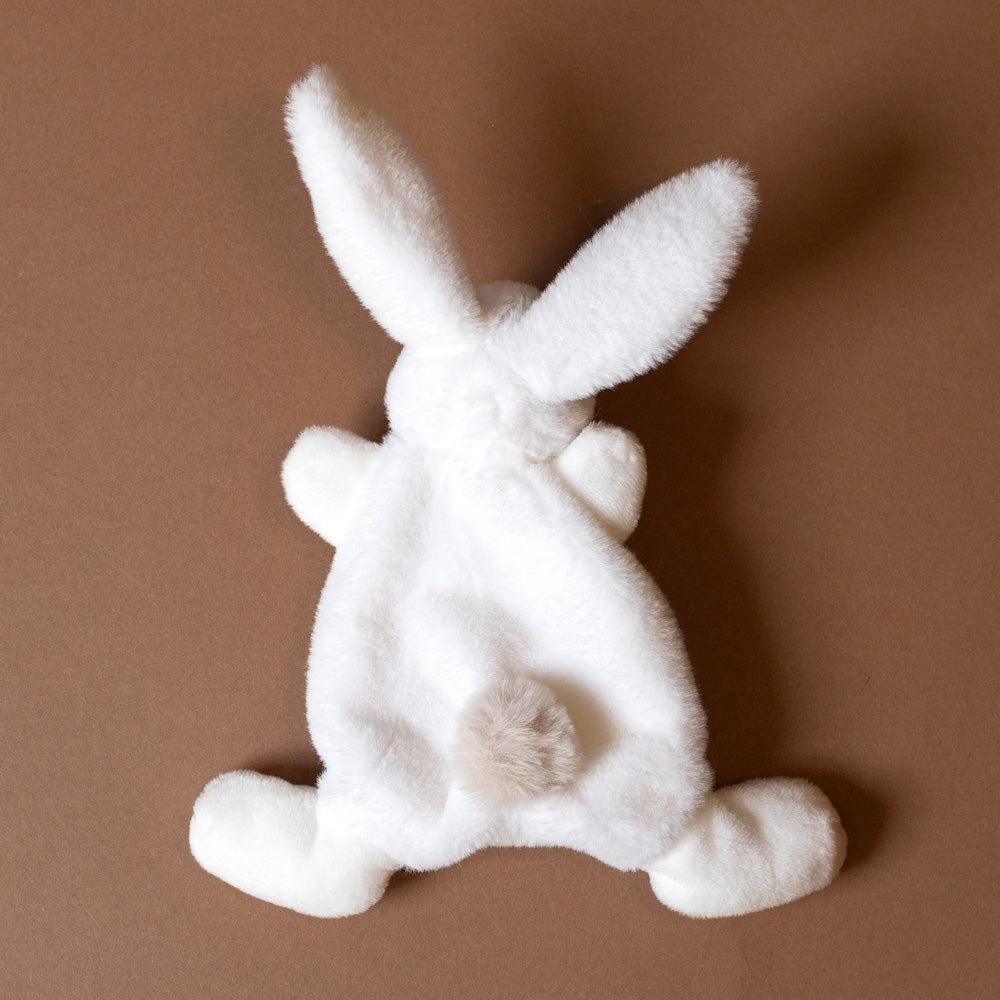 petite-bunny-lovie-happy-wild White plush bunny toy on a brown background