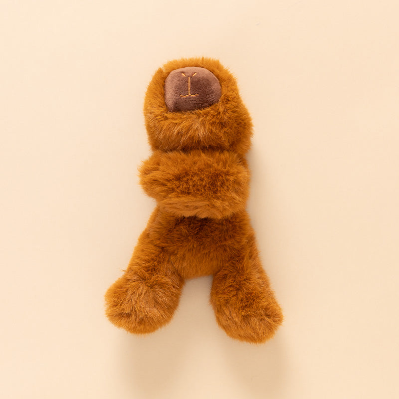 A small brown plush petite-gluepot-capybara toy lying on its back on a warm cream background