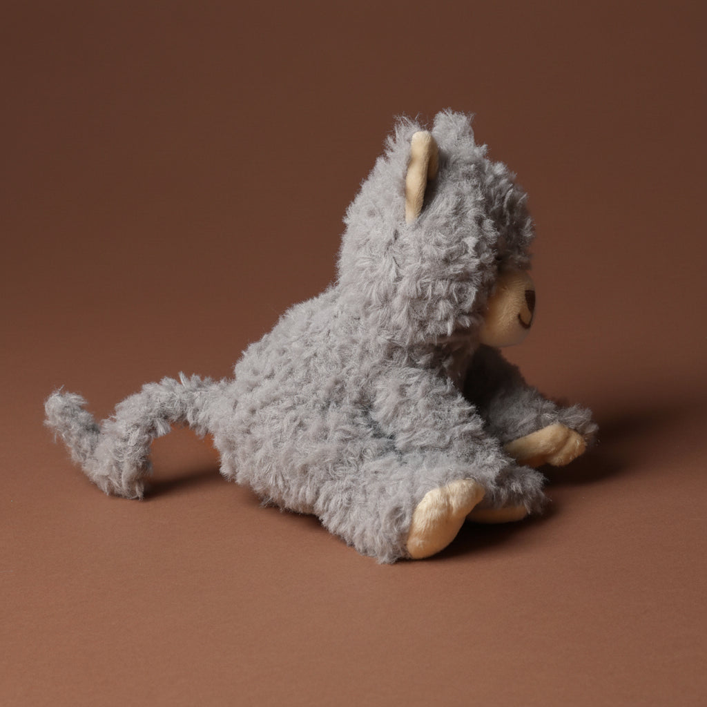 Plush toypetite-romy-the-cat-blueberry on a brown background