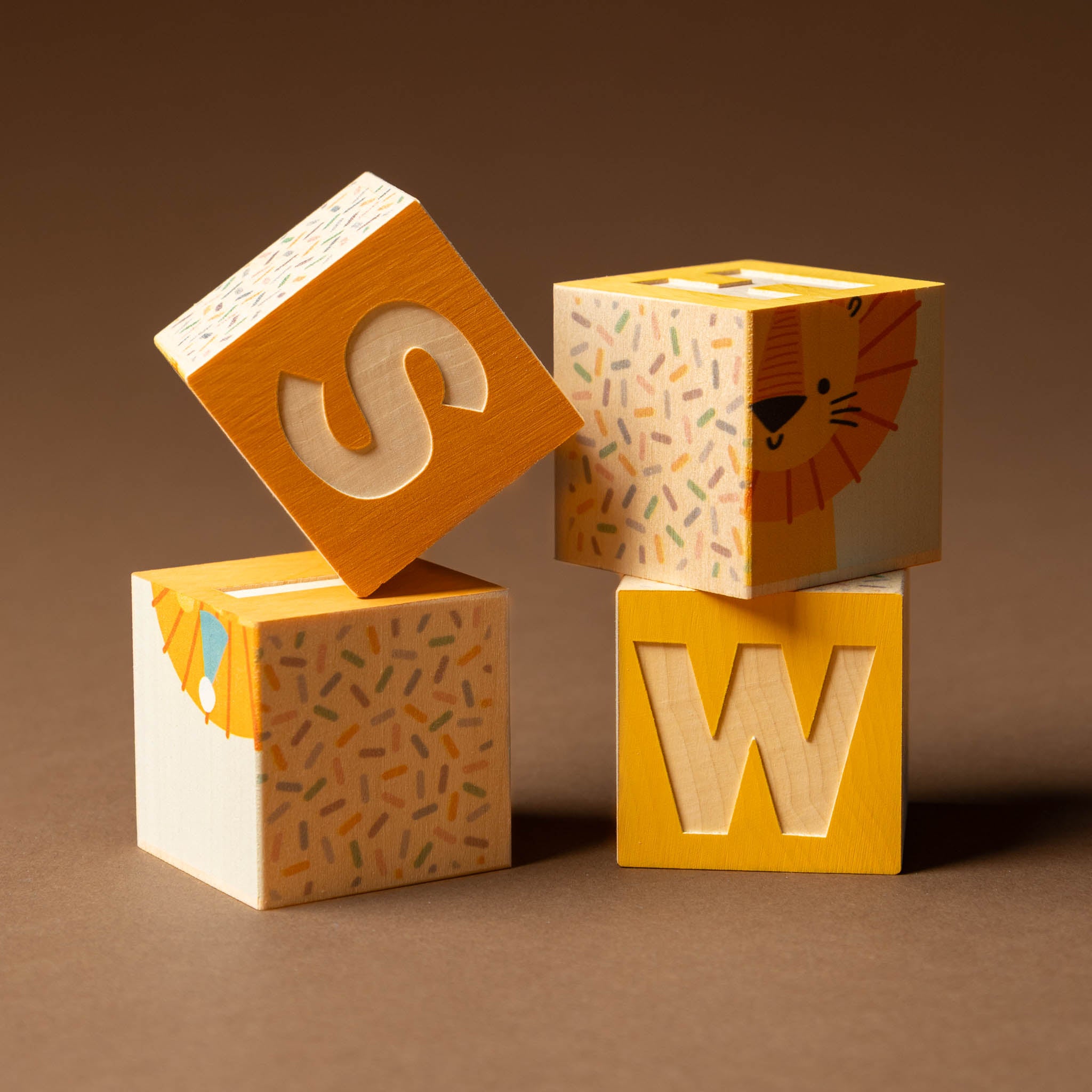petite-wooden-gifting-block-set-wishWooden blocks with letters 'S', and 'W' on a brown background