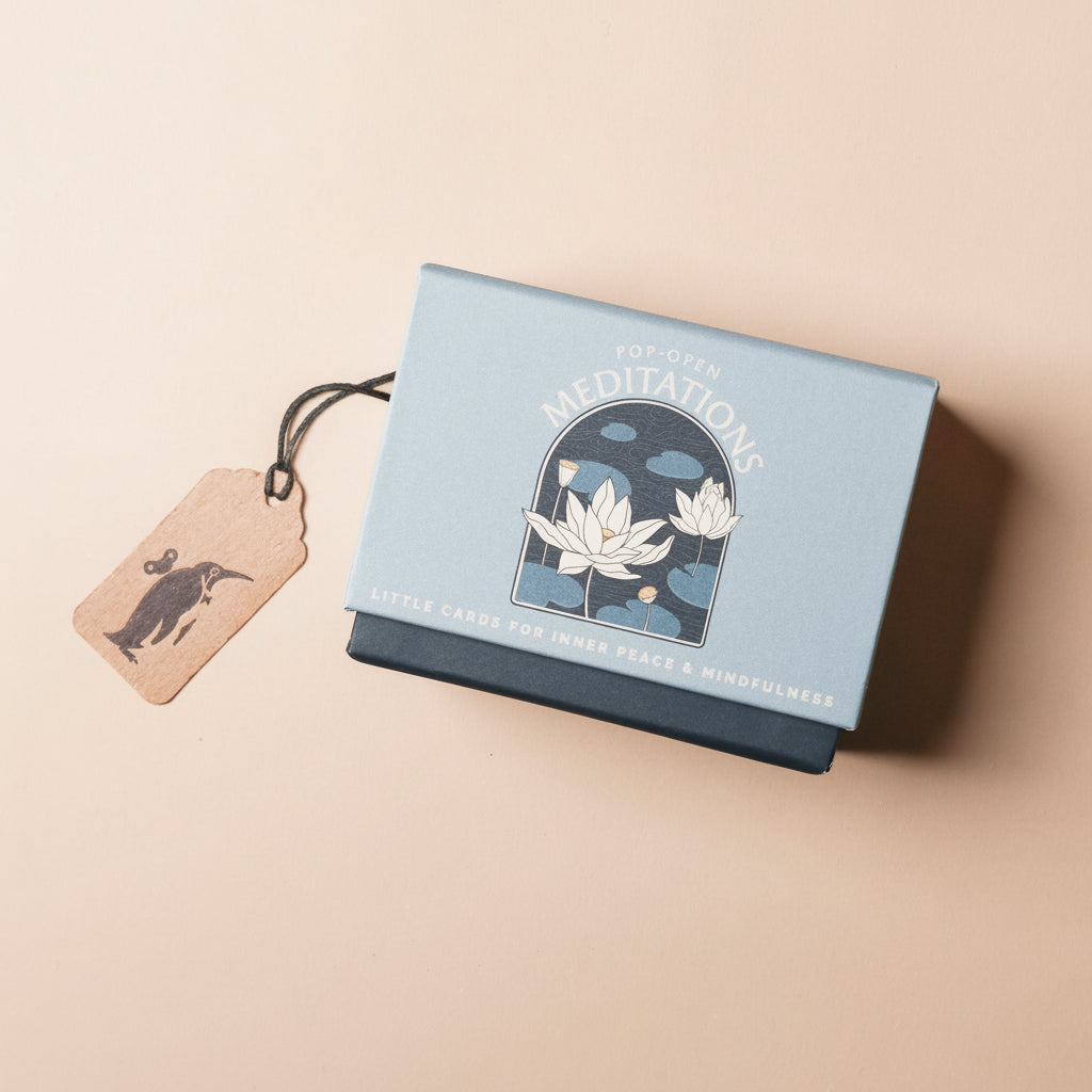 Box of 'Pop-Open Meditations' cards with lotus flower design on a beige background