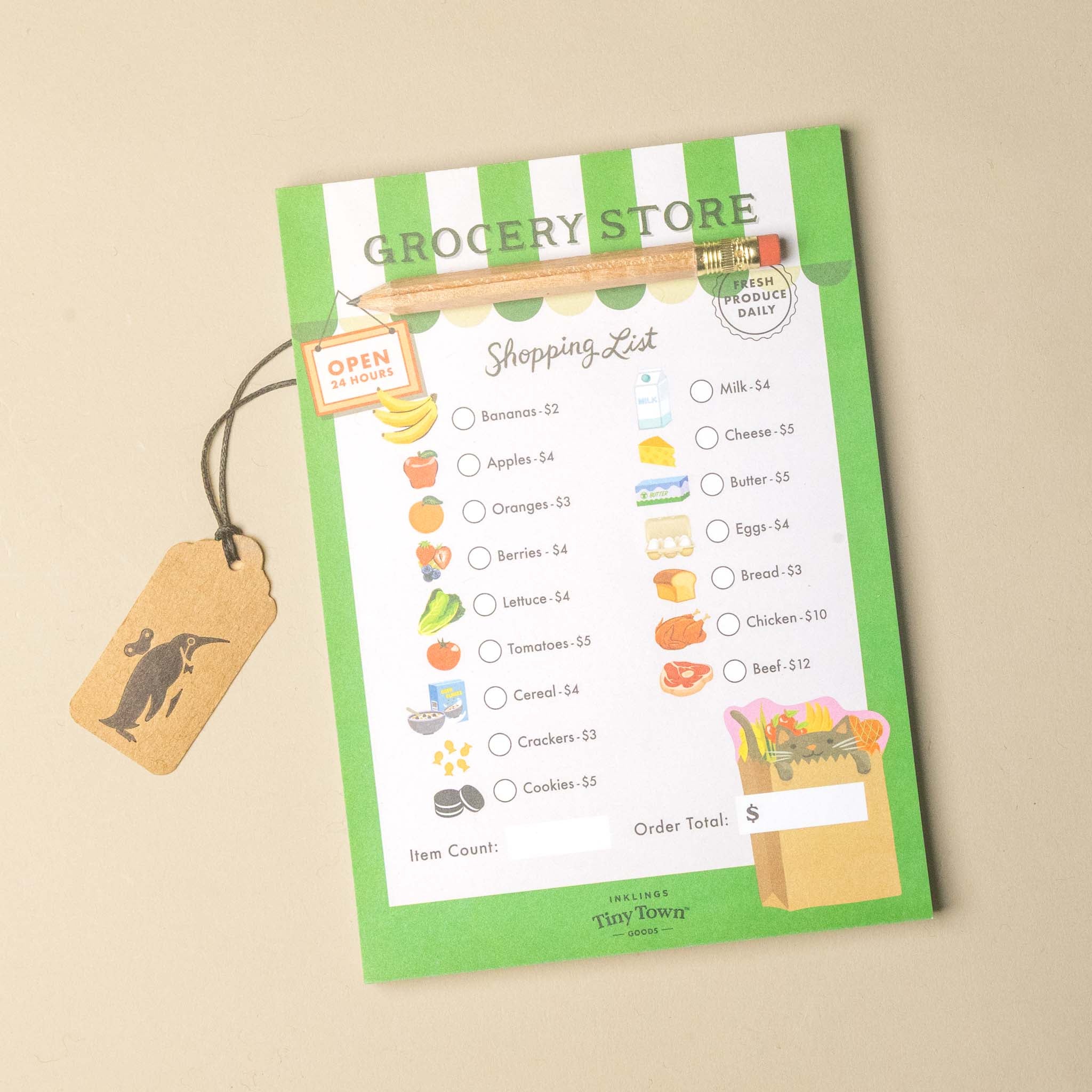 A green and white striped grocery store shopping list checklist card with illustrations of various foods, a hanging kraft paper tag with a kangaroo silhouette, and a wooden pencil clip, displayed on a neutral beige background.