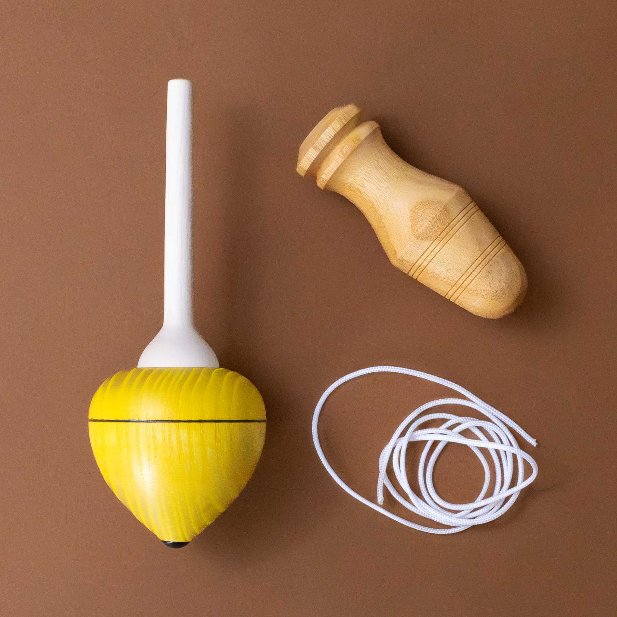 pull-string-wooden-spinning-top-with-yellow-base-pulled-into-functional-pieces