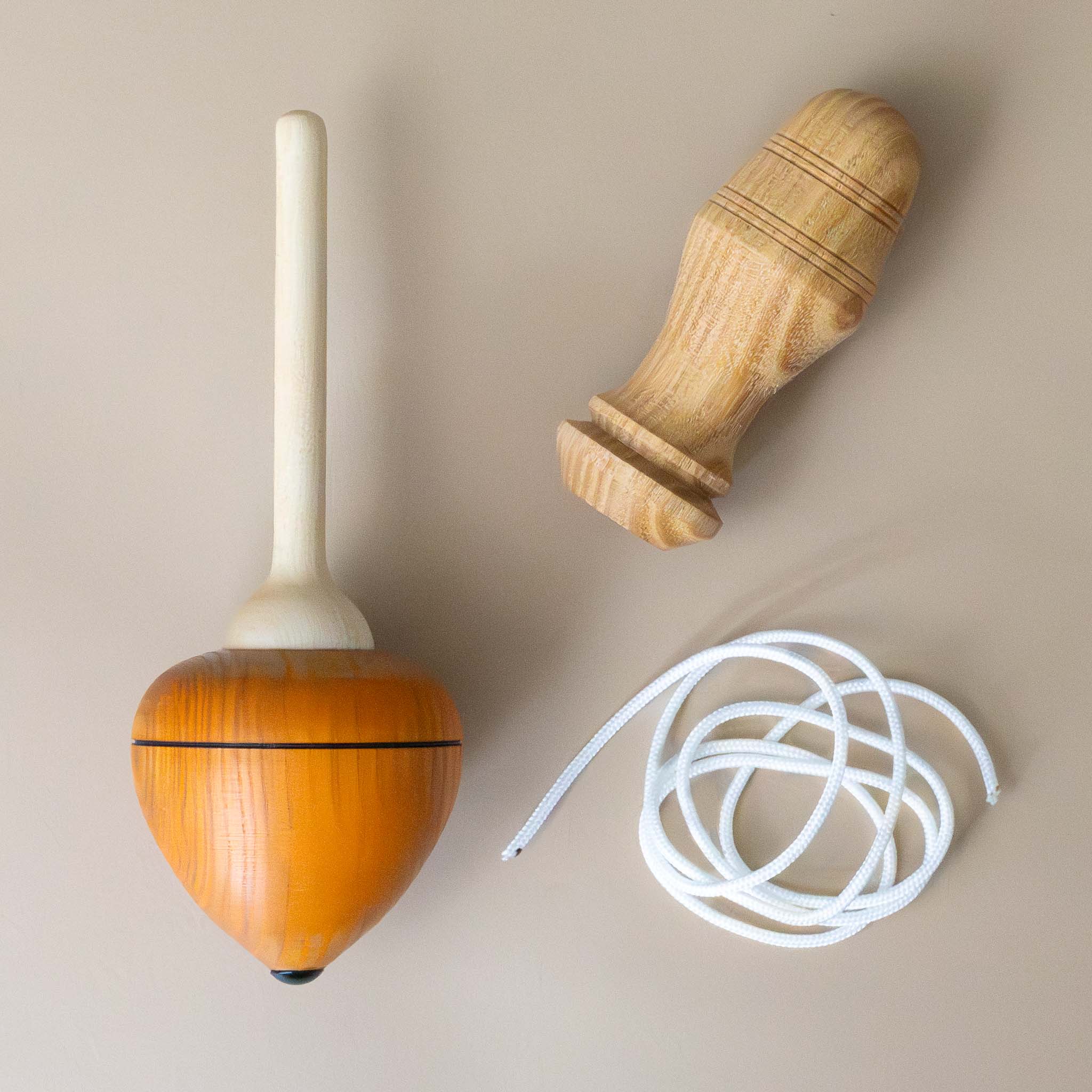 pull-string-wooden-spinning-top-with-orange-base-pulled-into-functional-pieces