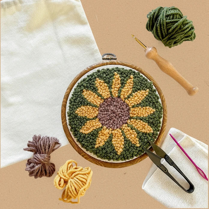 Embroidery hoop with sunflower design, yarn, and tools on a white background, featuring The Urban Acres brand.