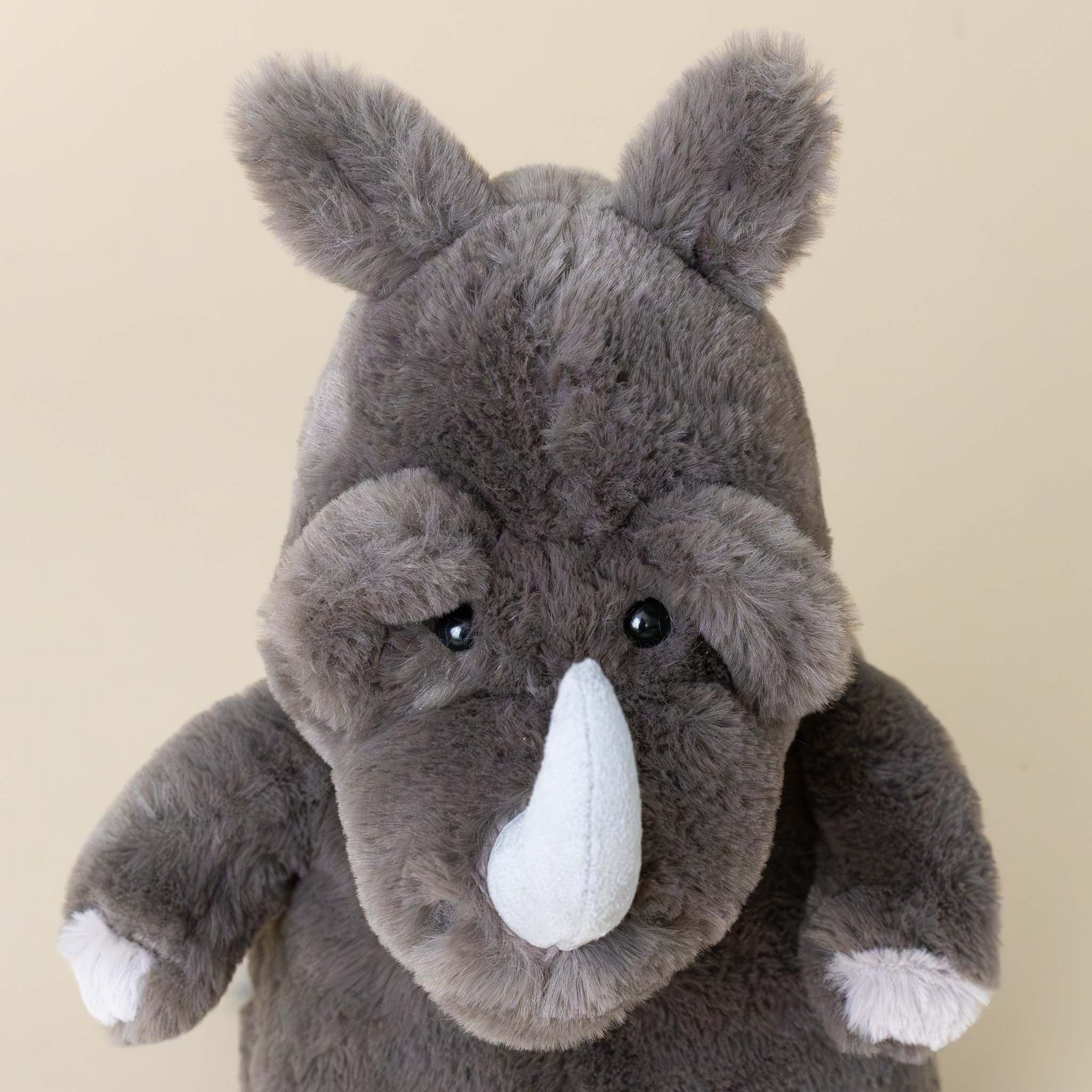 roderick-rhinoceros-grey-stuffed-animial-with-light-grey-horn-hooves-and-fluffy-tail-face