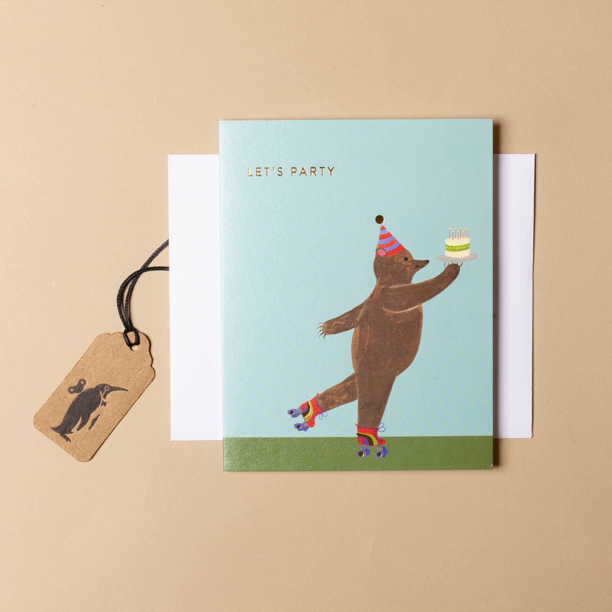 Greeting card with a bear wearing a party hat and holding a cake, on a beige background.