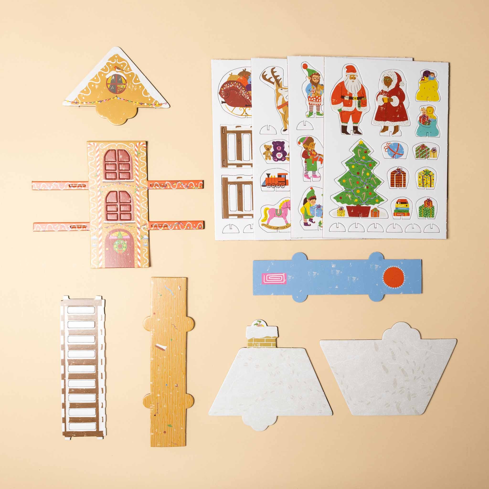santas-workshop-a-pop-and-play-activity-kit Set of Christmas-themed paper cutouts on a beige background