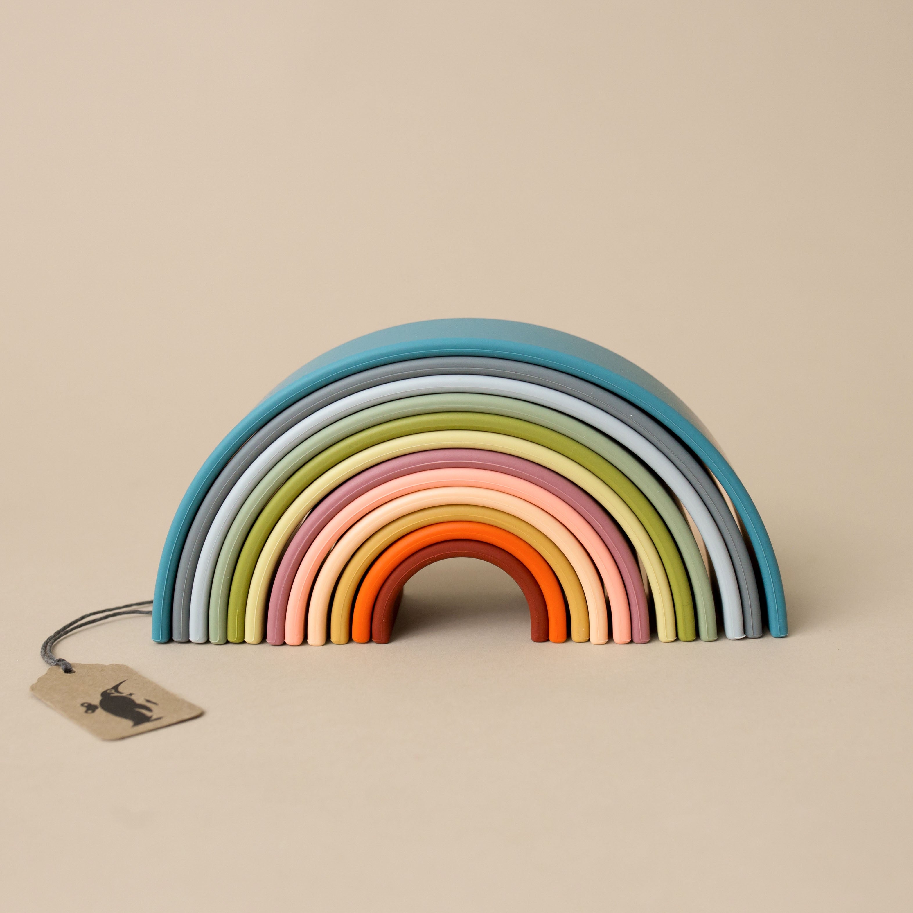 silicone-rainbow-nature-large Colorful wooden rainbow toy on a beige background