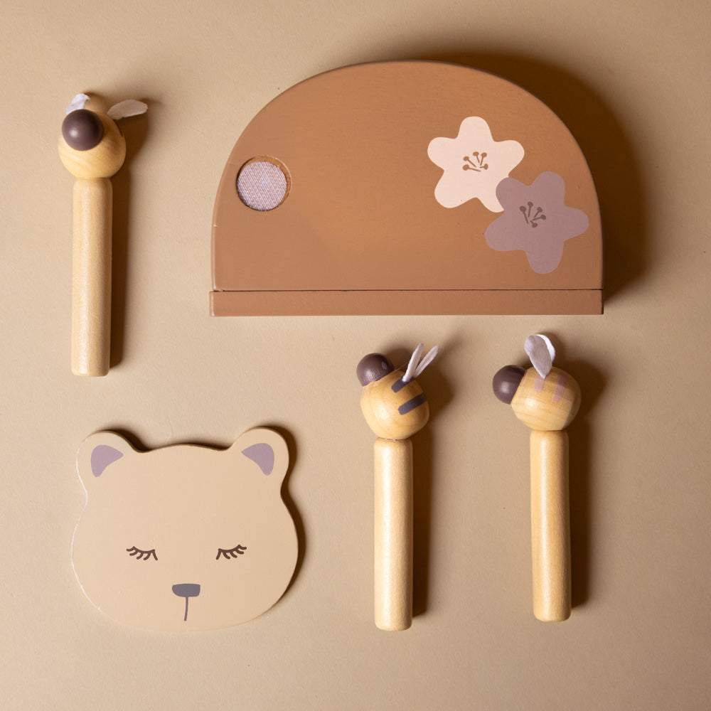 sleeping-bear-and-the-bees Set of wooden toys with animal designs on a beige background