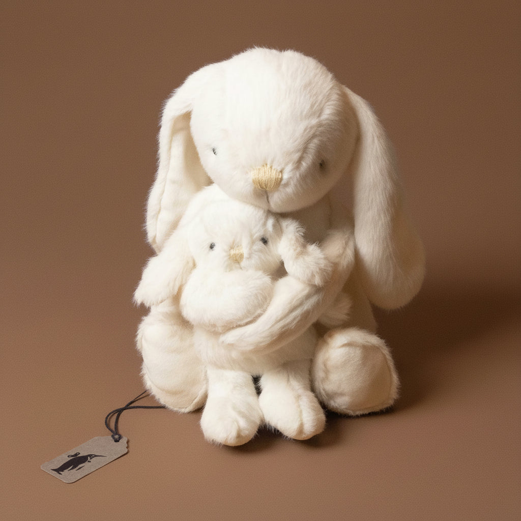 White plush snuggle-bunnies-marshmallow toy with a tag on a brown background