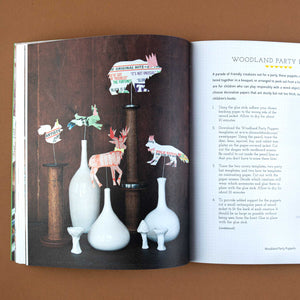 interior-page-showing-magazine-animal-cutouts-displayed-in-vases-for-a-woodland-party-theme