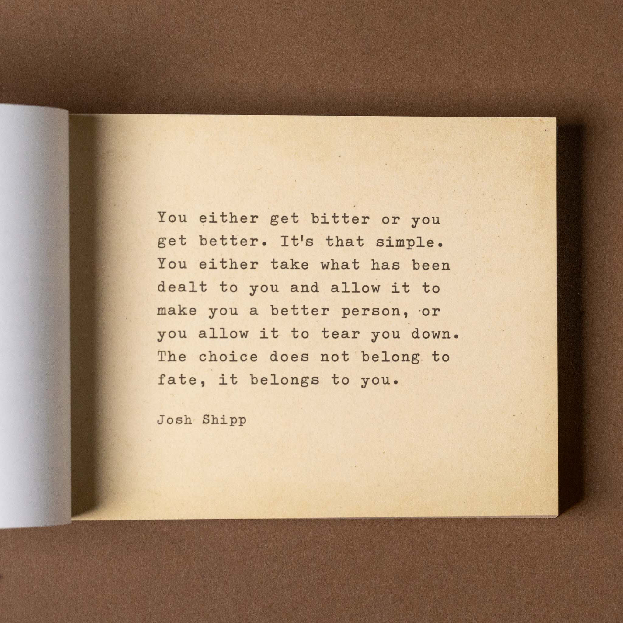 the-little-book-of-encouragement Open book with a motivational quote on a brown background