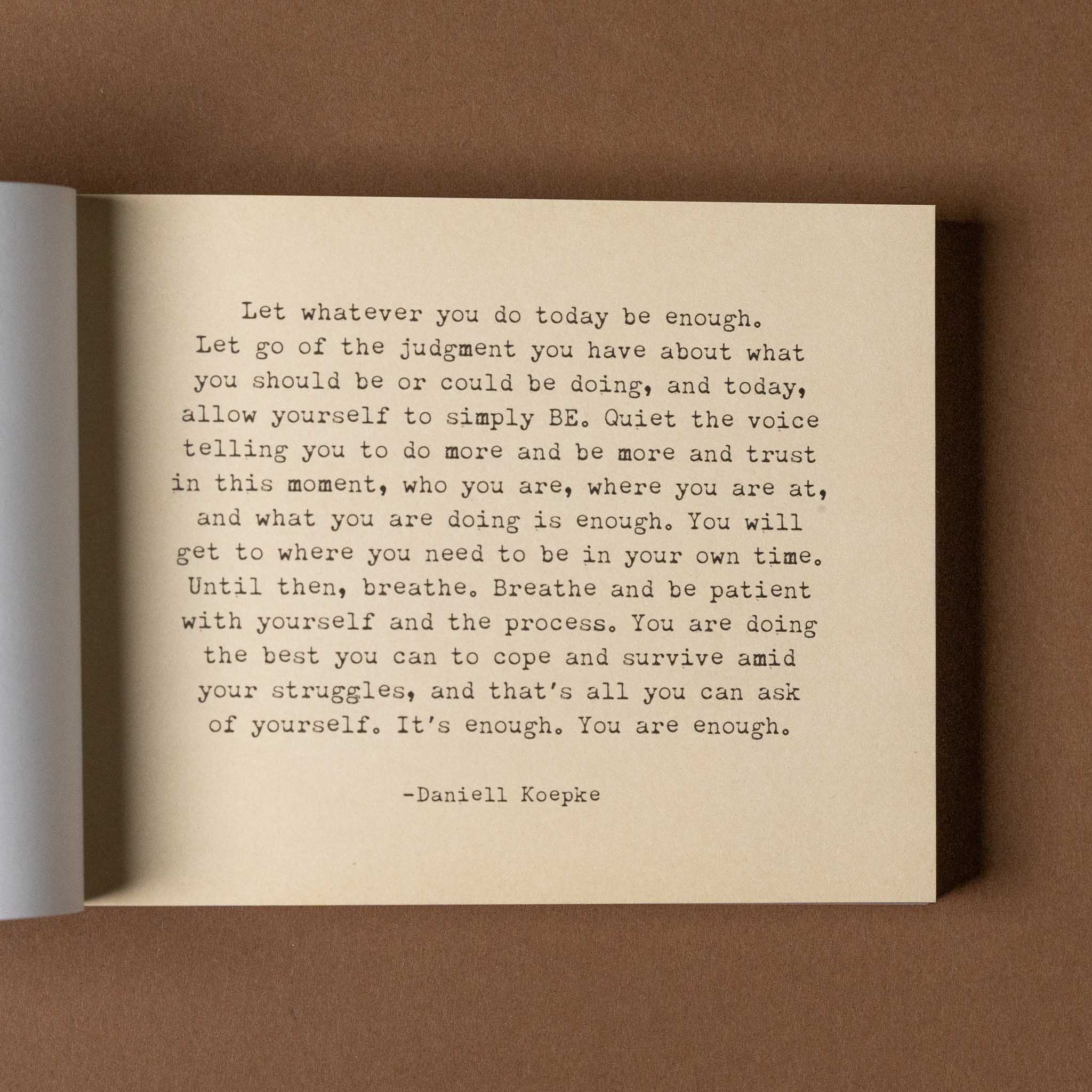 the-little-book-of-encouragement Open book with a motivational quote on a brown background