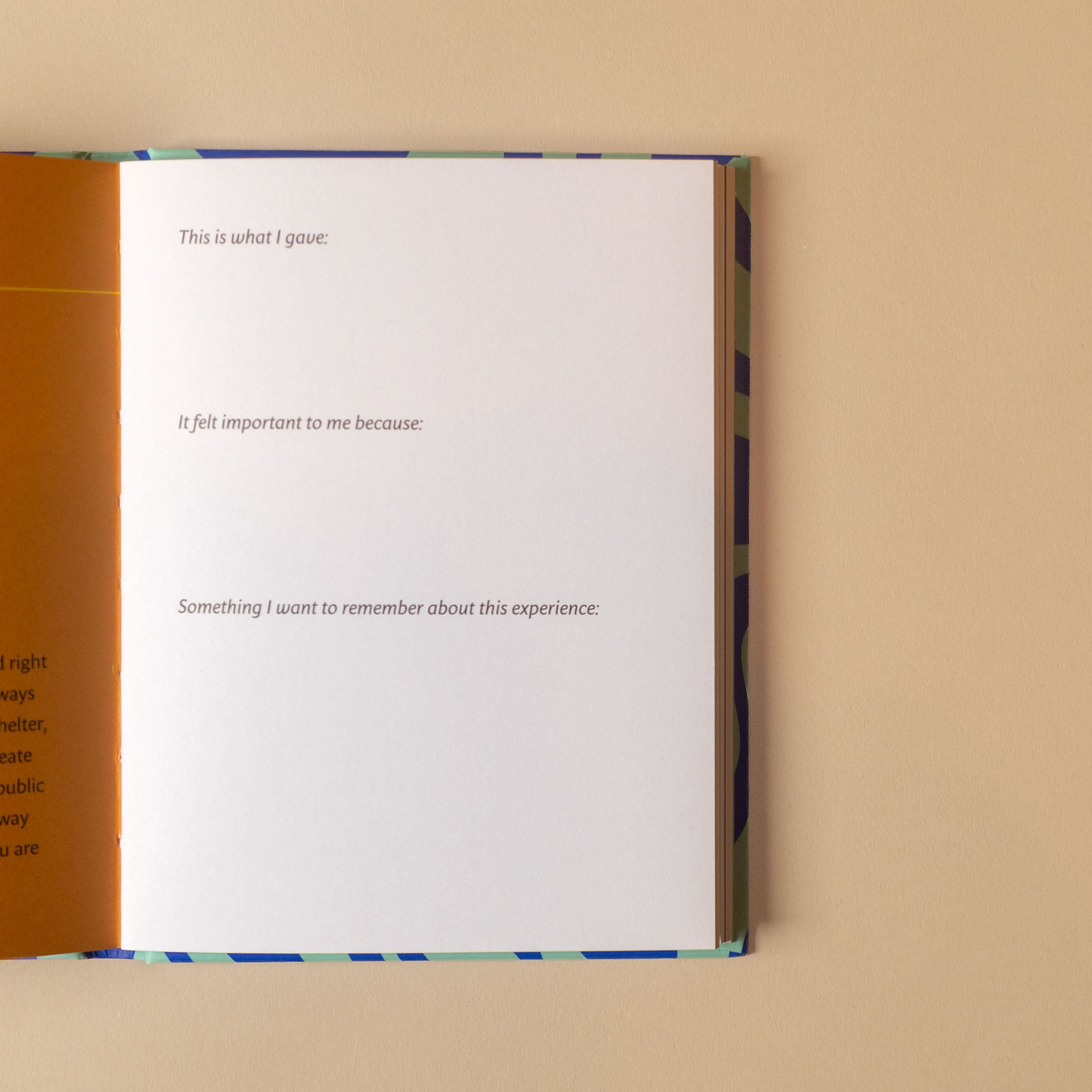 An open book or journal on a beige background, showing a white page with printed prompts and an orange left margin.