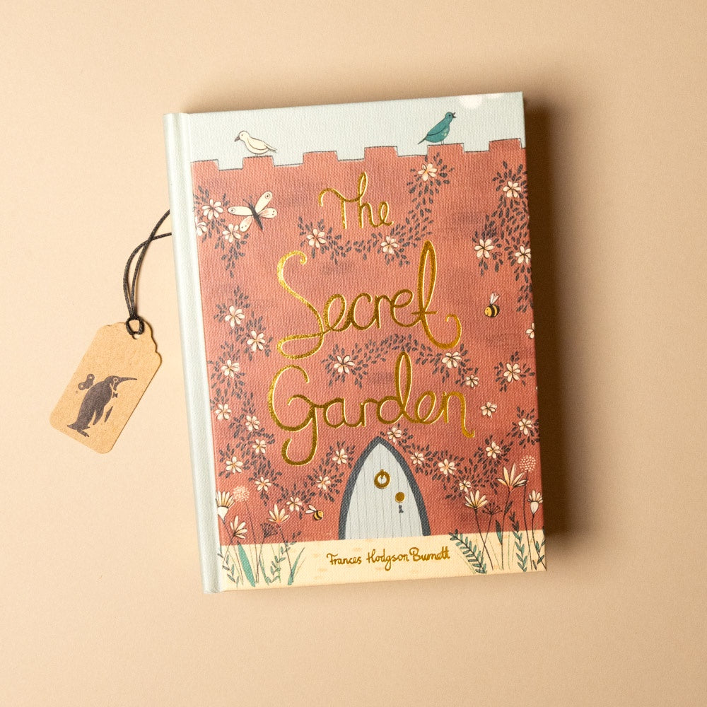 Book titled 'The Secret Garden' with floral design and tag on beige background