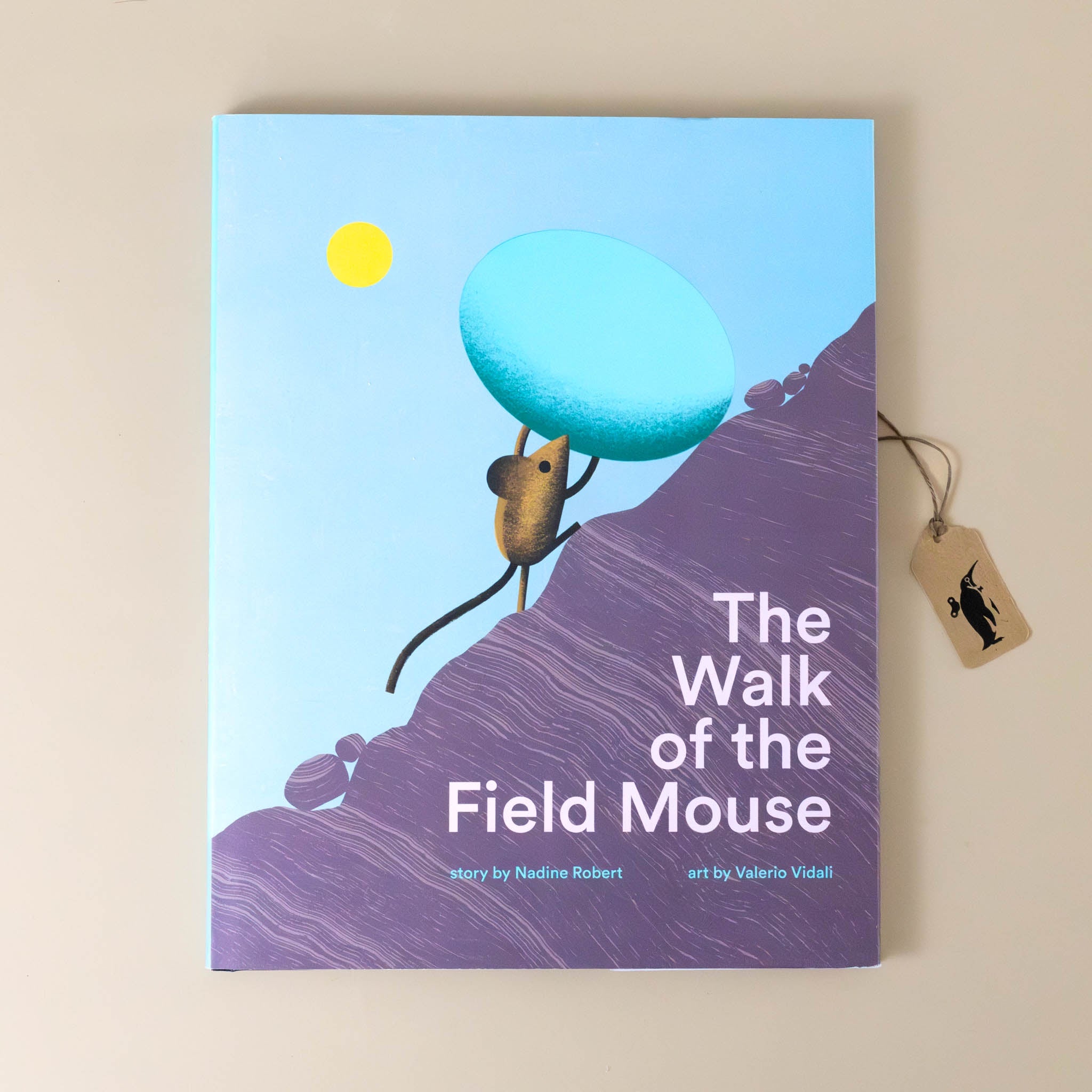 the-walk-of-the-field-mouse-book-cover-with-a-mouse-pushing-a-egg-up-a-hill