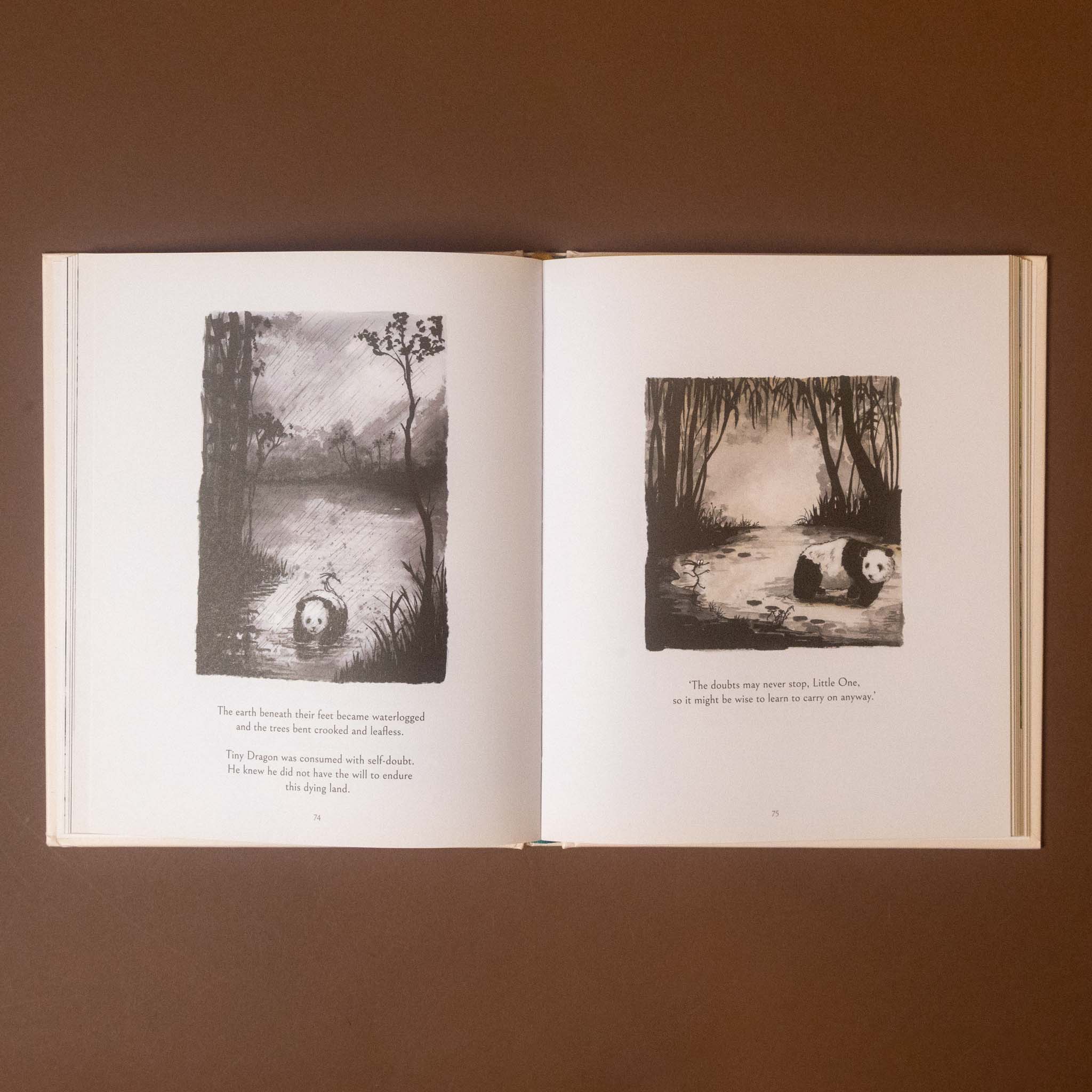 An open children's picture book displayed flat against a solid brown background. The book's pages are off-white with two black-and-white illustrations and short text, showing a forest scene with a figure in the left page and a panda in the right page.