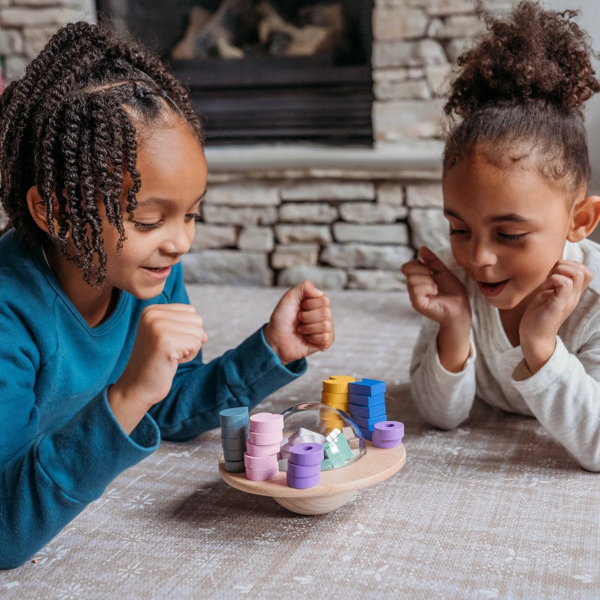 Two children playing with colorful toys on the floor in a cozy living room.