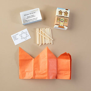 components-showing-riddle-matchstick-puzzle-and-orange-paper-hat-housed-within-beige-holiday-home-matchsitck-box