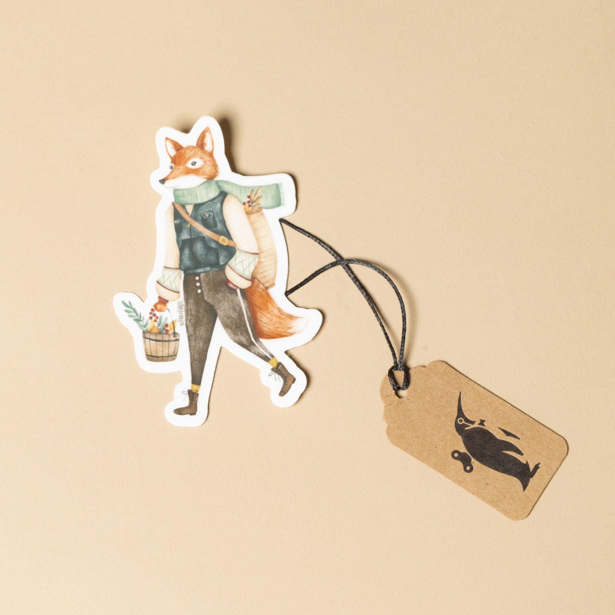 Sticker of a fox character with a tag on a beige background