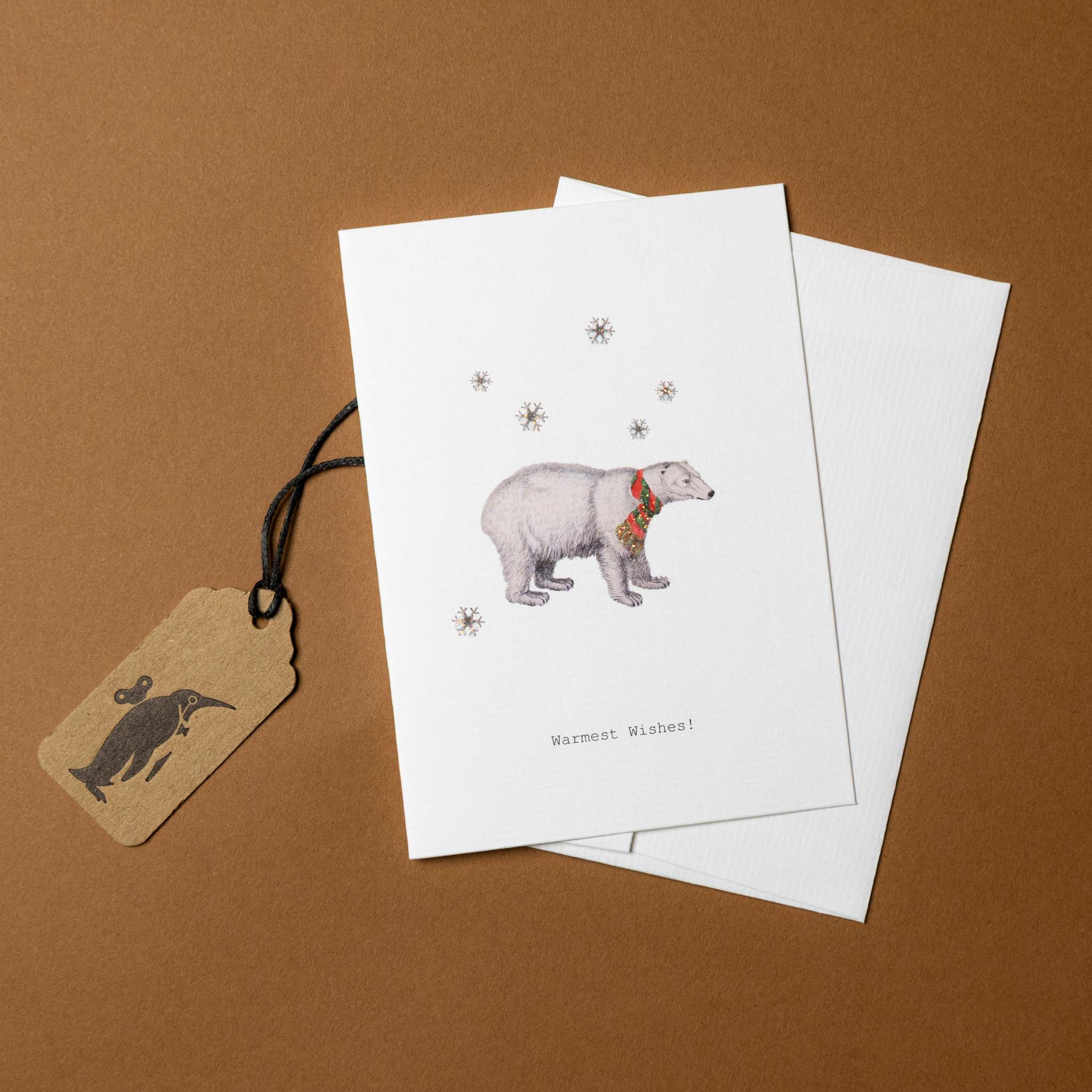 white-greeting-card-illustrated-polar-bear-in-scarf-and-black-text-reading-warmest-wishes