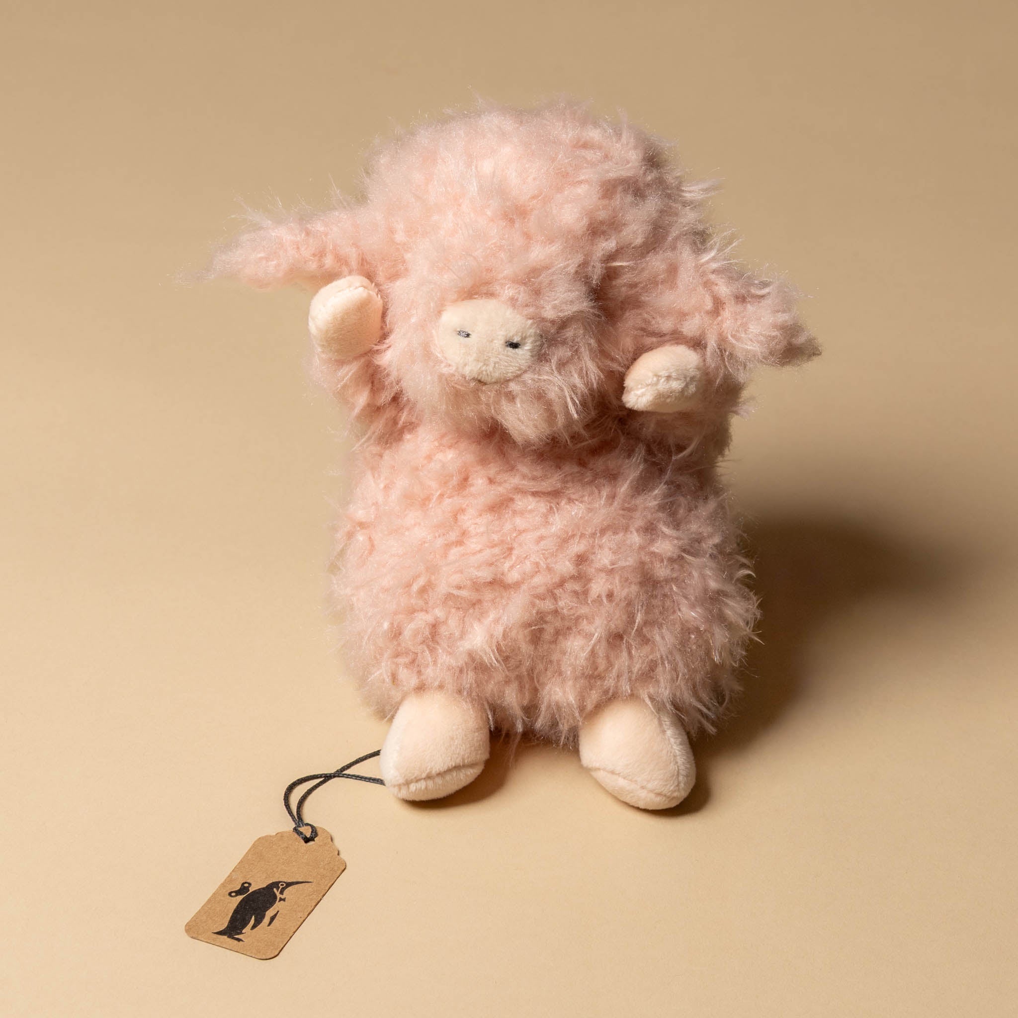 wee-piggy-hammie Pink plush toy sheep with a tag on a beige background