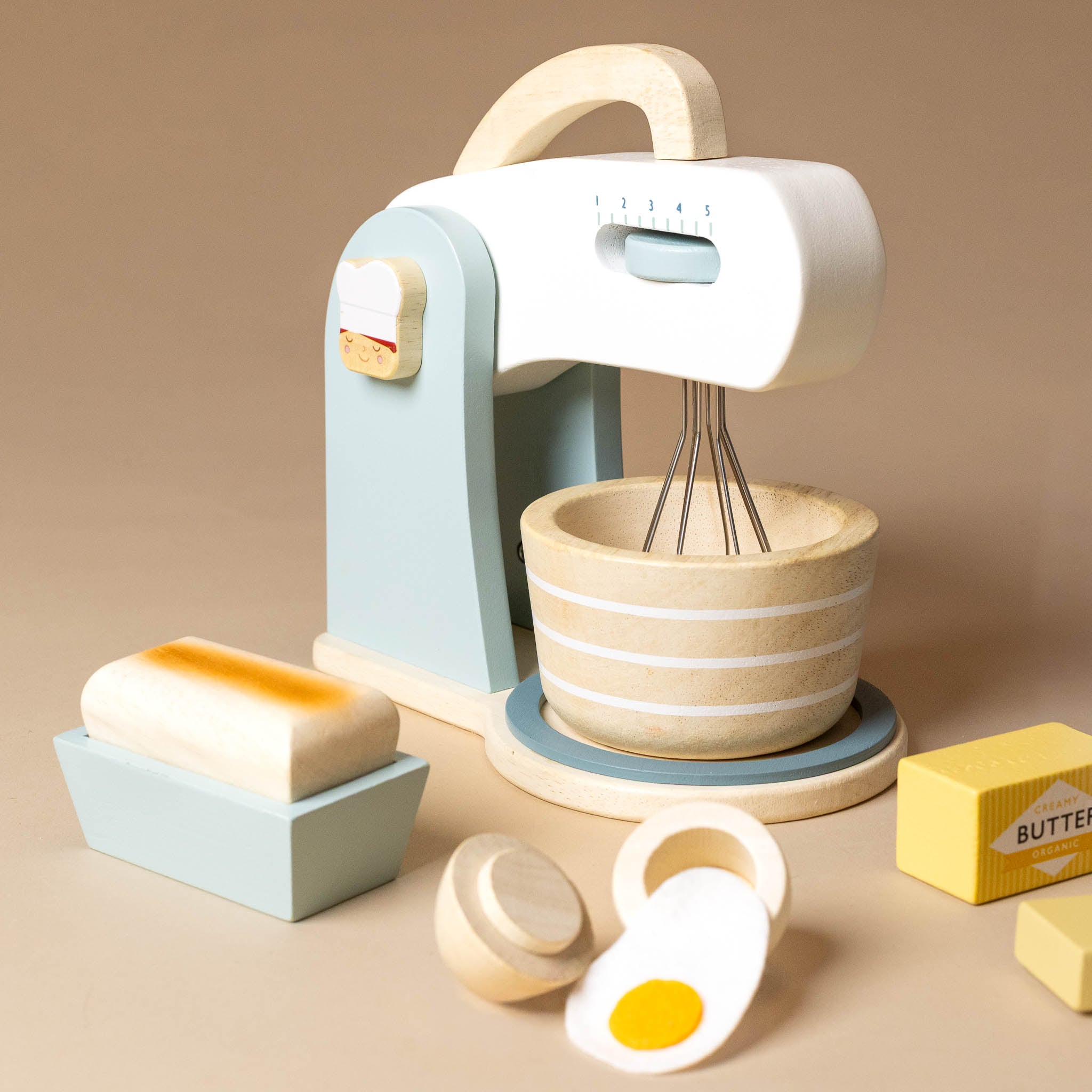 wooden-bake-a-cake-play-set Toy kitchen set with mixer, bowl, and ingredients on a beige background