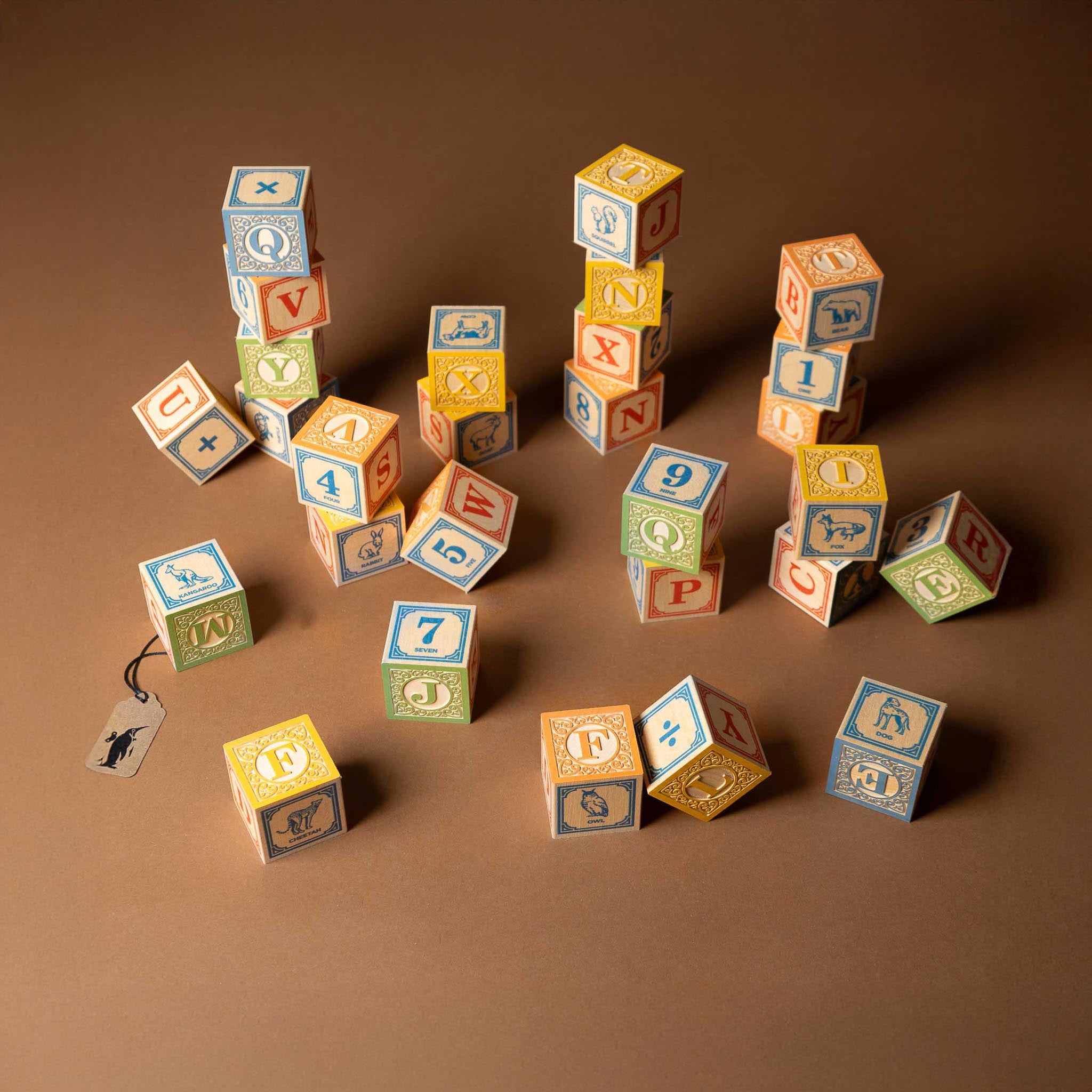 wooden-block-set-with-canvas-bag-classic-abcs Colorful wooden blocks with letters and numbers on a brown background