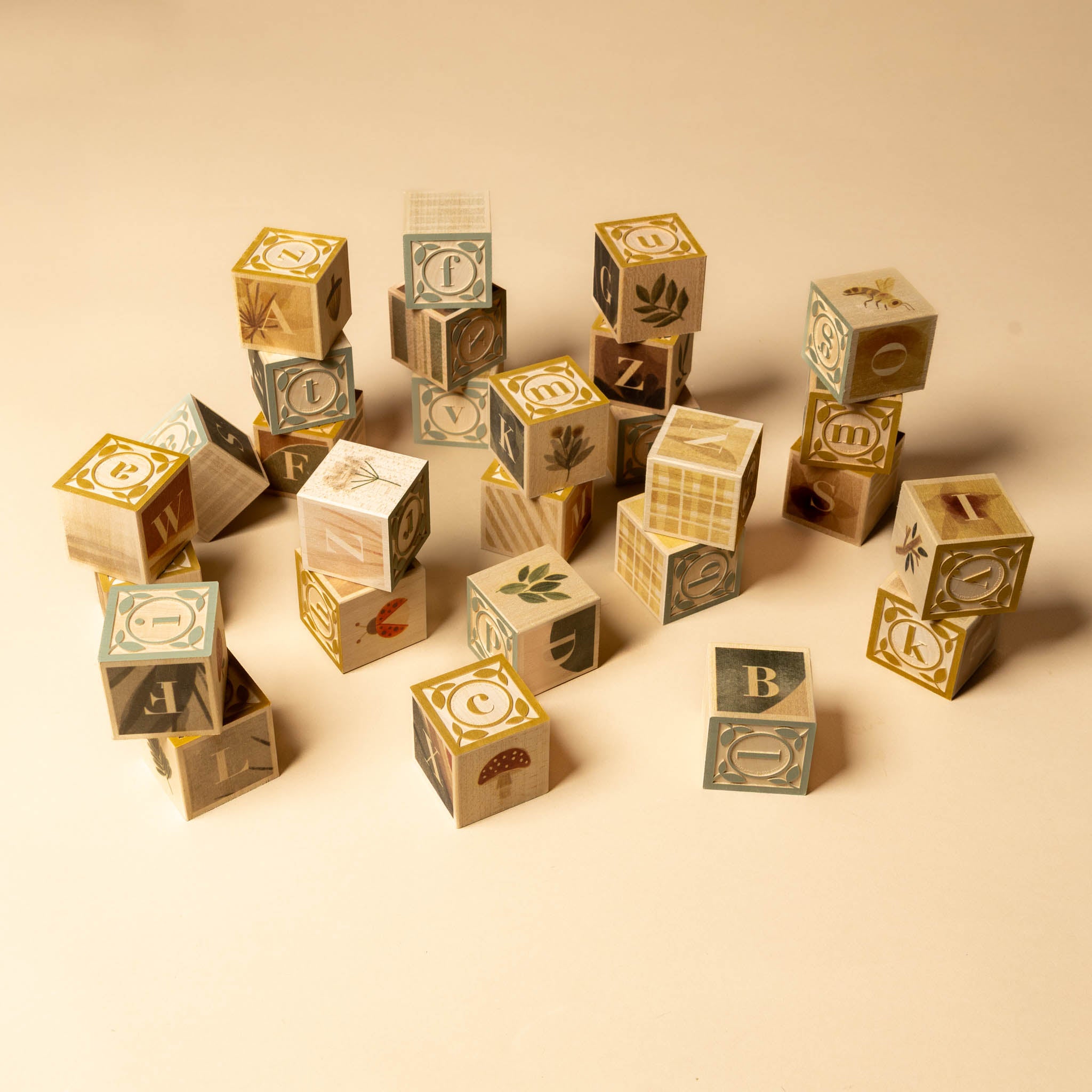 Wooden Block Set | Watercolor Alphabet Set of wooden blocks with letters and nature-themed designs on a beige background