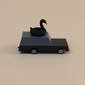 side-of-grey-and-black-wooden-toy-car-with-black-swan-on-roof