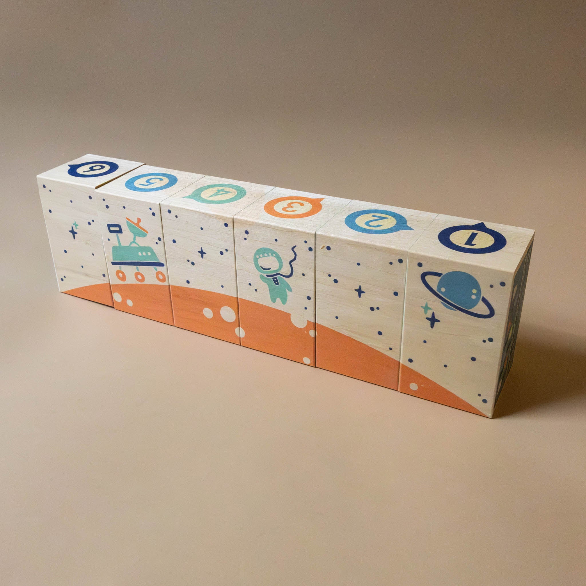 stacked-blocks-with-sastronaut-space-ship-and-numbers-in-blue-and-orange